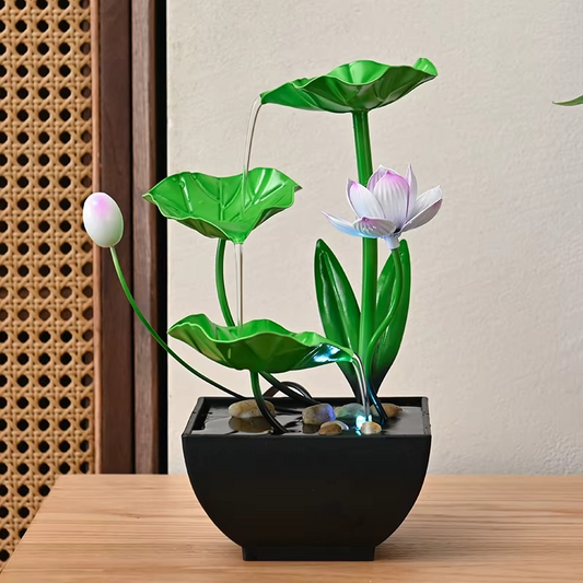 Decorative water fountain with lotus design on a wooden surface.