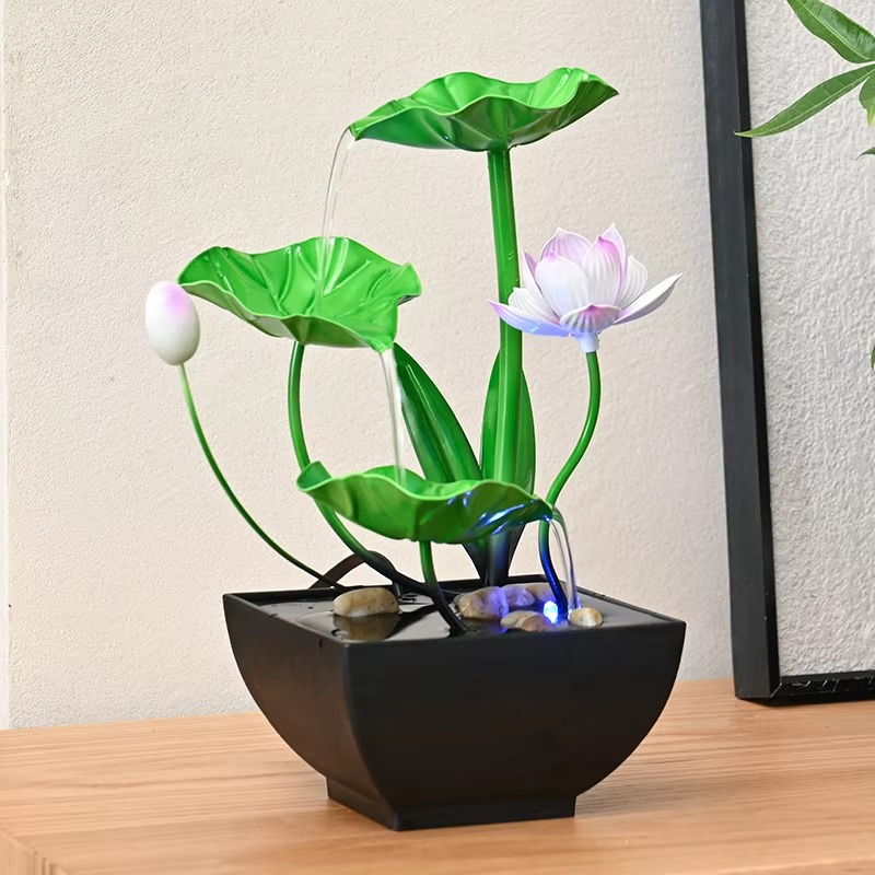 Decorative water fountain with lotus design on a wooden surface.