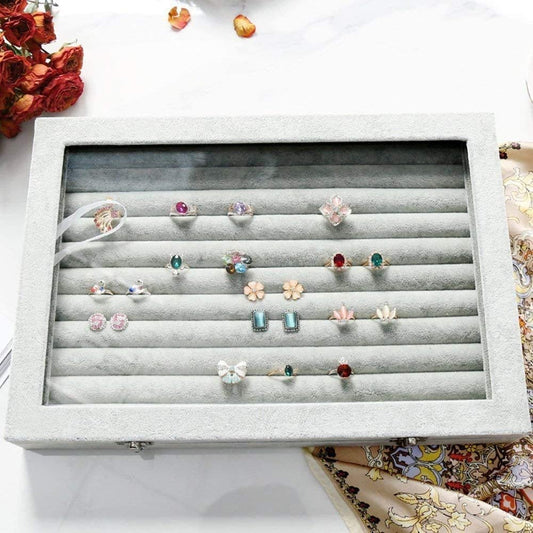 Display of earrings in a jewelry box with flowers in the background