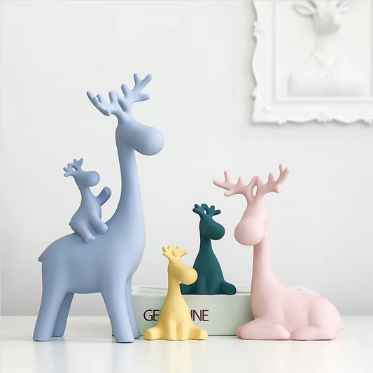Set of colorful deer figurines on a white surface with a light gray background