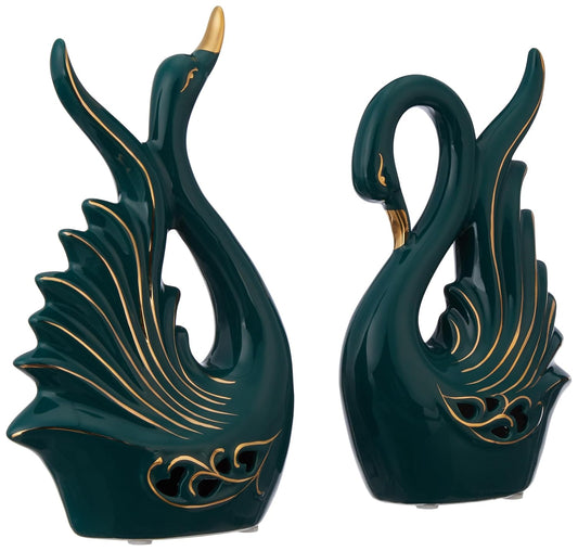 Two green ceramic swan sculptures with gold accents on a white background