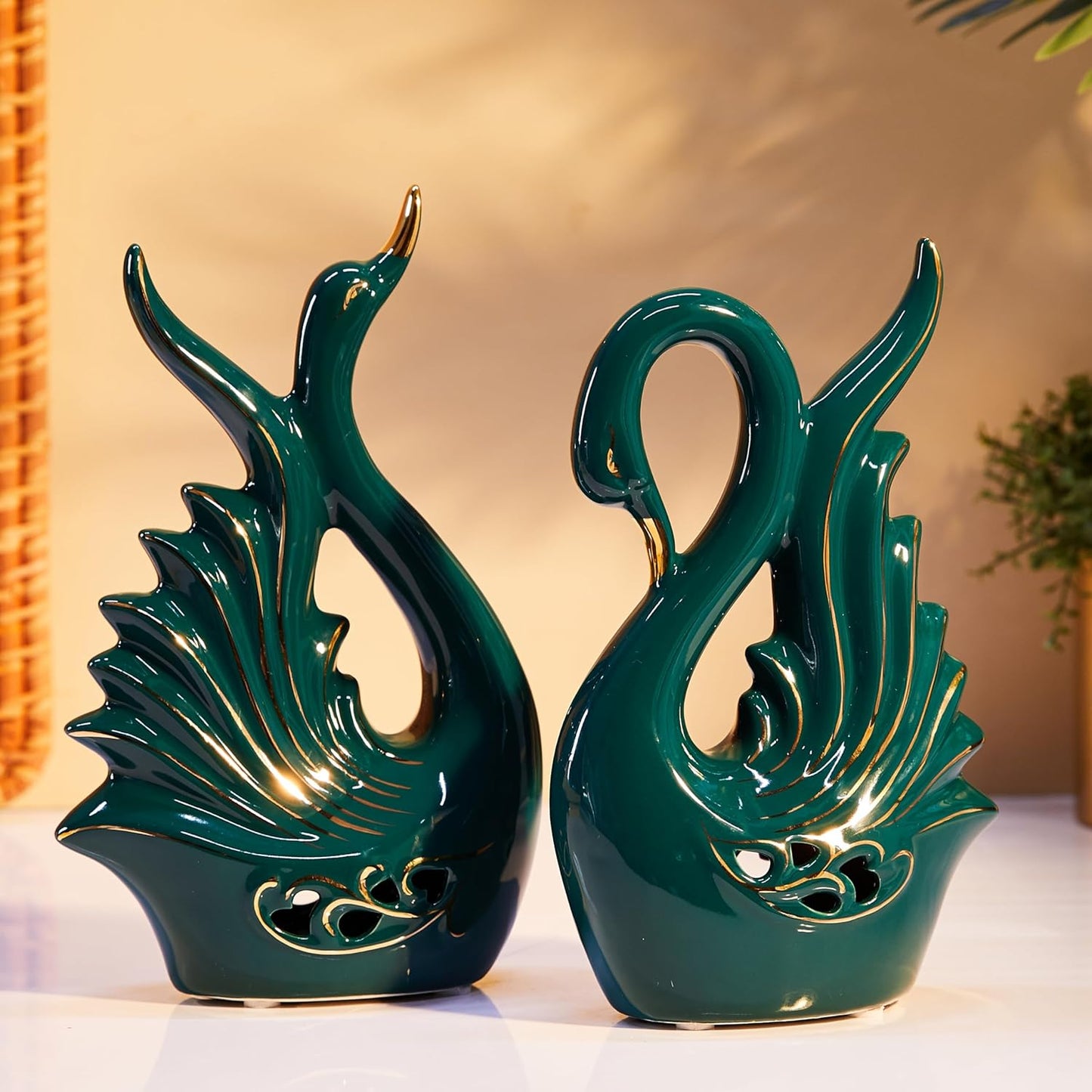 Two green ceramic swan statues on a light background
