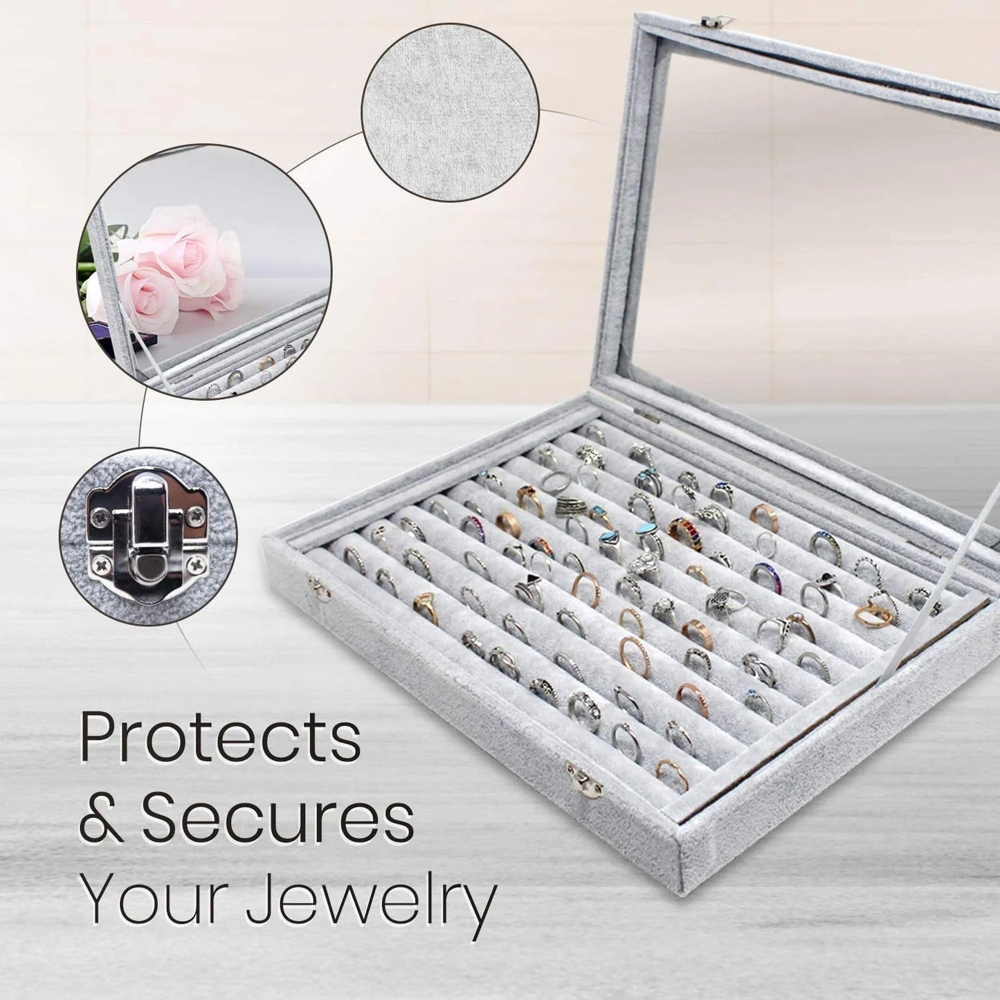 Gray jewelry display case with rings, glass lid, and velvet interior on a light background.