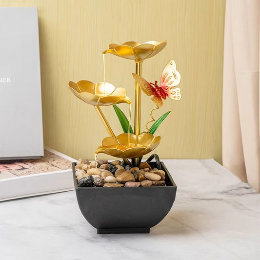Decorative lamp with gold flower design and butterfly on a marble surface.