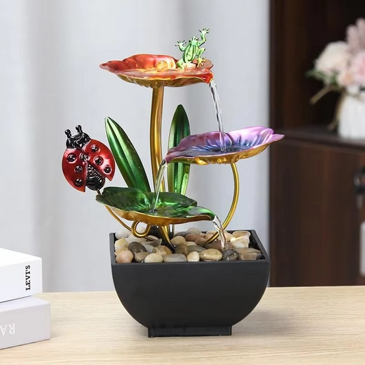 Decorative water fountain with a ladybug and frog on a table