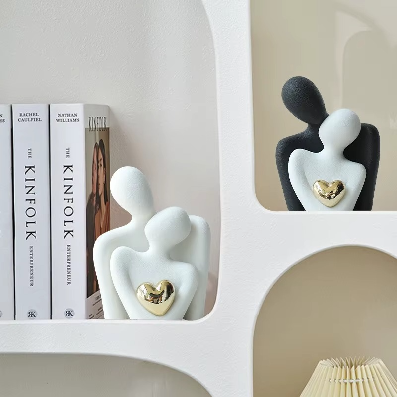 Decorative figurines of a couple with a heart on a shelf with books in the background