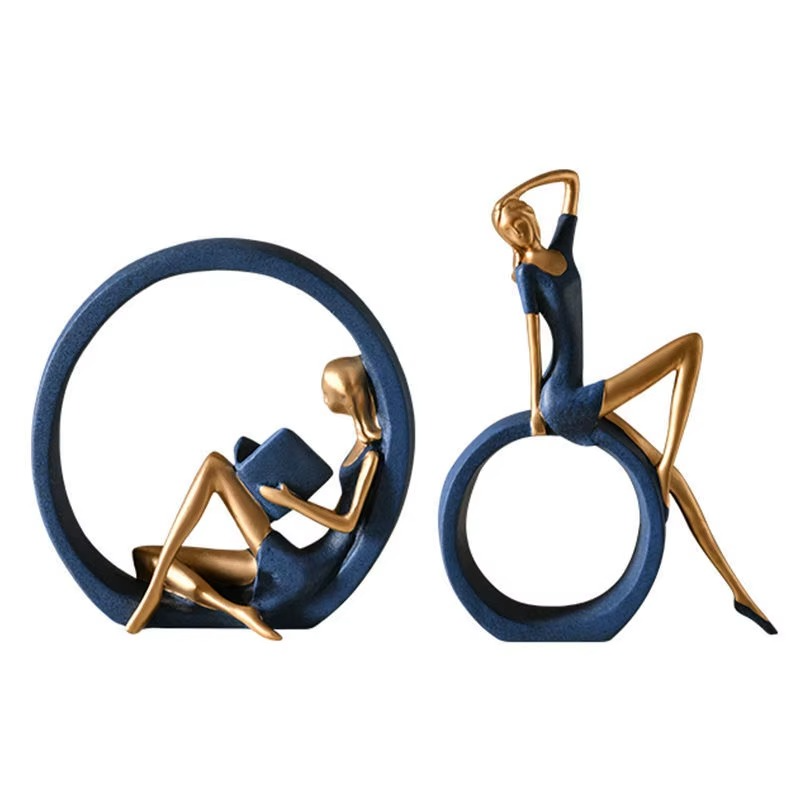 Two decorative statues of people on circular bases with a white background