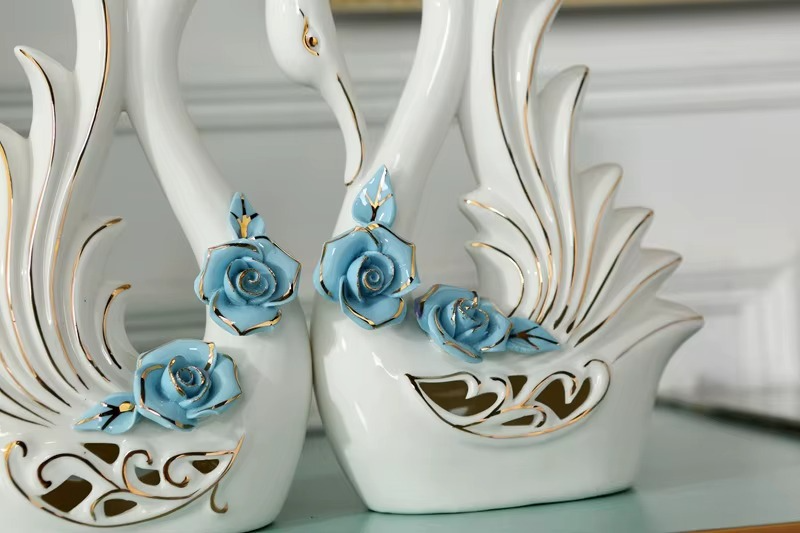 Decorative white swans with blue rose details on a light background