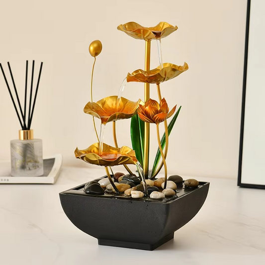 Decorative water fountain with gold lotus designs on a light background