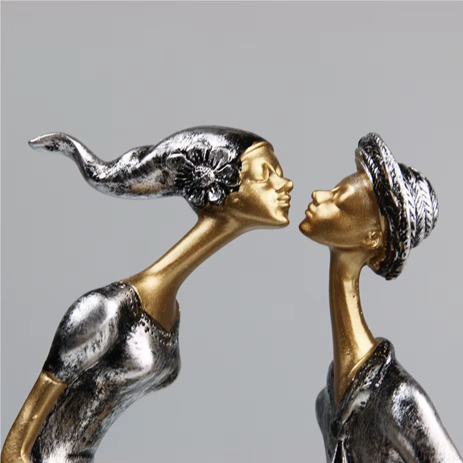Two bronze figurines facing each other against a gray background