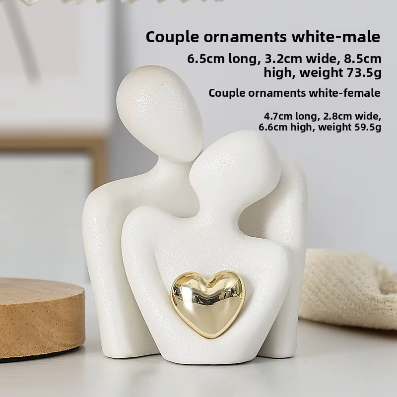 White ceramic couple ornament with a gold heart on a light background