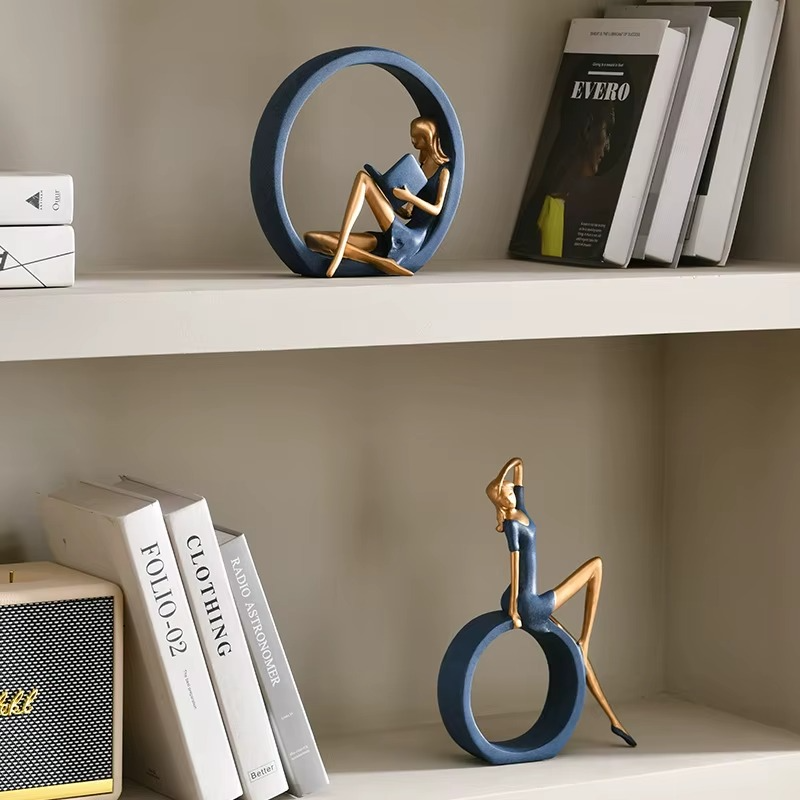Decorative sculptures of a woman on a ring on a shelf with books