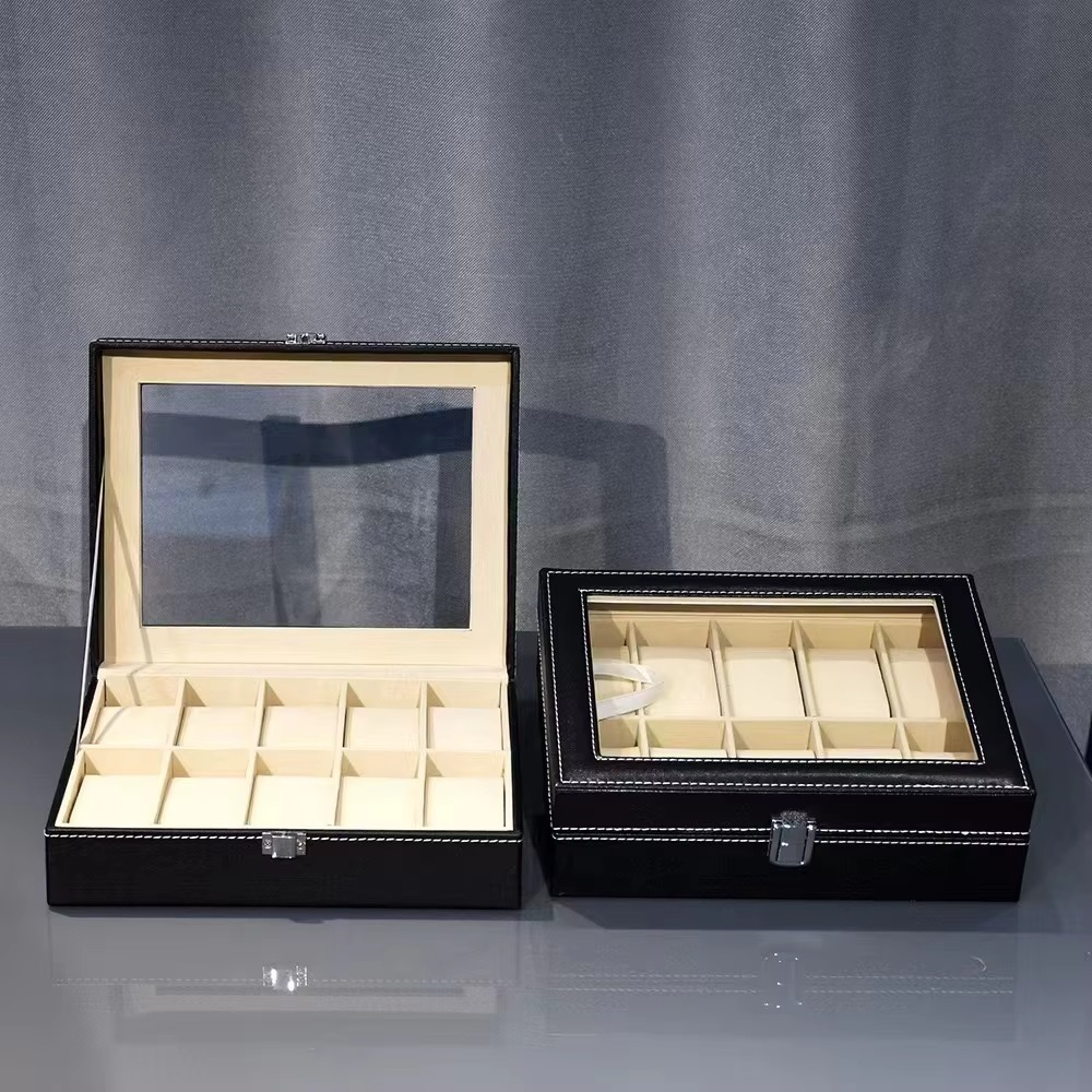 Two black jewelry boxes with glass tops on a gray background